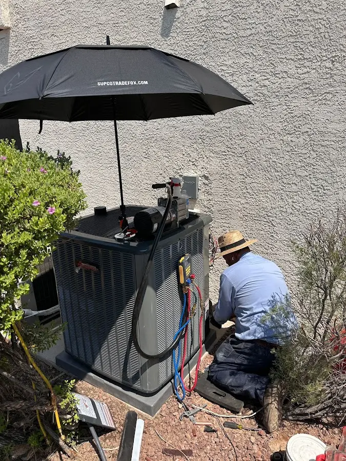 HVAC technician performing outdoor AC maintenance in Birmingham